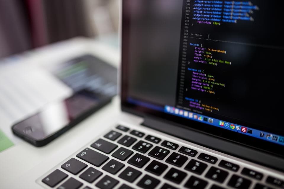 Écran d'ordinateur portable affichant du code de développement, illustrant les bénéfices d'un audit DevOps pour une PME