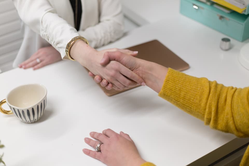 Poignée de main professionnelle autour d'un bureau, symbole d'un accord conclu lors d'une levée de fonds