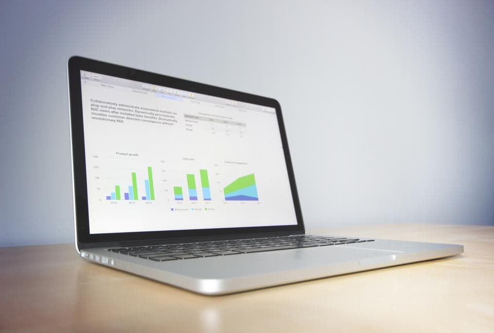 Laptop displaying charts on a wooden desk, illustrating common cyber weaknesses in small businesses