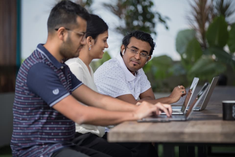 Product team working together on their laptops outdoors, illustrating a product discovery approach
